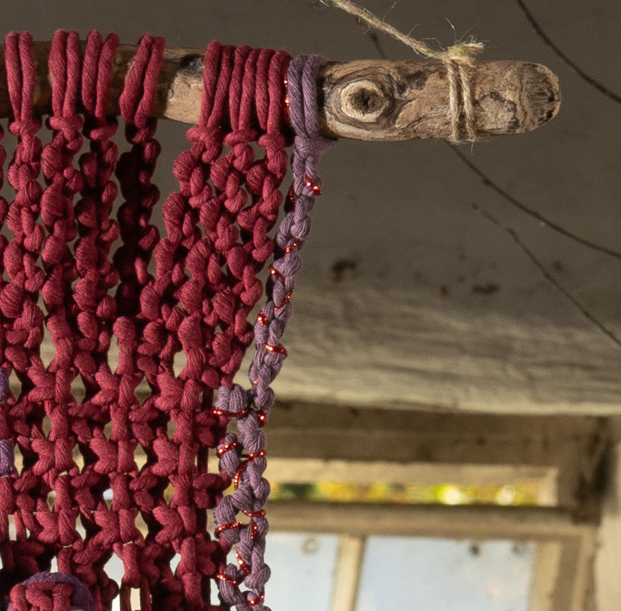 Thumbnail: Aubergine and Blue is knotted on to a natural driftwood dowel