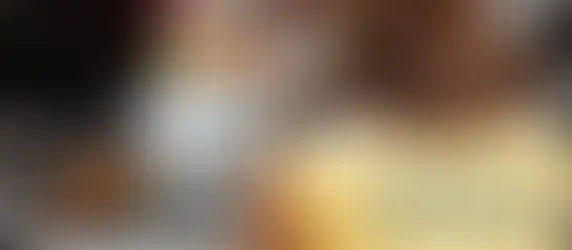 mulher está de costas com blusa da vigilância em saúde enquanto avalia uma garrafa de bebida alcoólica em um bar