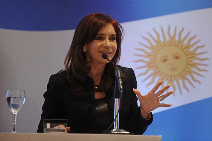 Cristina Kirchner com bandeira da Argentina ao fundo