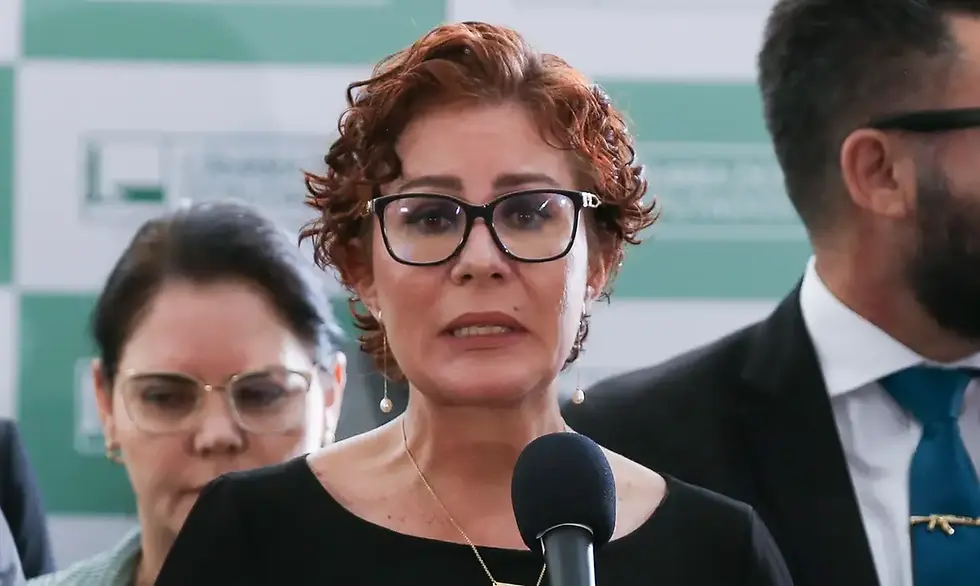 Carla Zambelli discursando com pessoas desfocadas no fundo