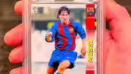 card de Lionel Messi sendo segurada por uma mão