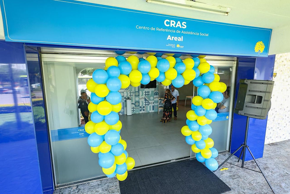 A imagem mostra a fachada de um prédio com uma placa azul na parte superior onde está escrito:CRAS Centro de Referência de Assistência Social Areal Há um arco de balões nas cores azul claro e amarelo decorando a entrada, indicando que provavelmente está acontecendo uma inauguração ou evento especial. Na placa também aparecem os logotipos da Secretaria de Desenvolvimento Social e do Governo do Distrito Federal (GDF).