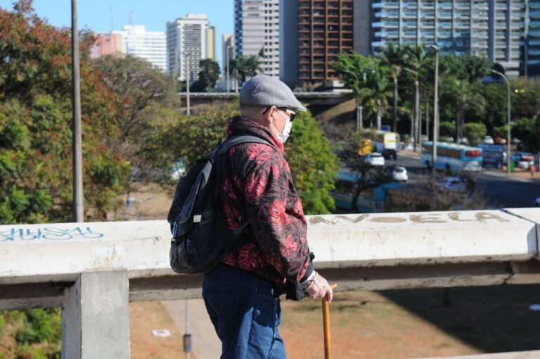 homem agasalhado atravessando a plataforma superior da rodoviária