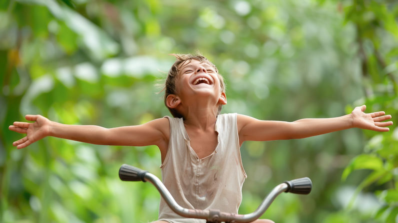 joyful-boy-with-arms-outstretched-riding-bicycle.jpg