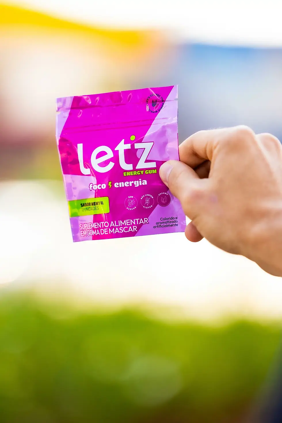 uma pessoa segurando pacote do Let'z Gum uma embalagem rosa forte