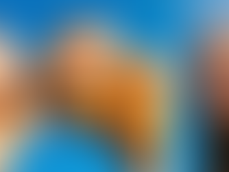 Close dinâmico de duas mãos jovens segurando copos de café gelado com canela (líquido laranja-marrom) contra um céu azul brilhante. Uma mão tem uma pulseira laranja. As pessoas estão rindo, com o sol batendo no rosto.