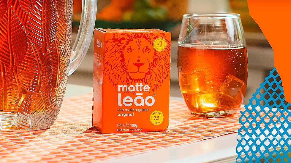 Chá matte leão de laranja em copo ao lado de embalagem de chá maté leão.
