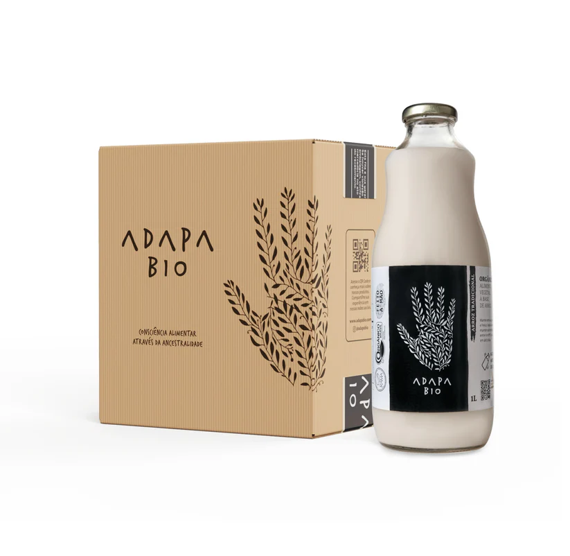 Imagem de leite vegetal Adapa Bio, em garrafa de vidro ao lado de uma embalagem de papelão, destacando o produto orgânico e sustentável.