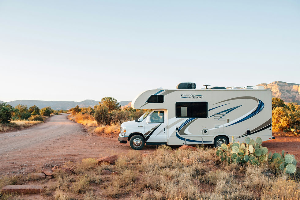 RV parked on a dirt road in the desert.
