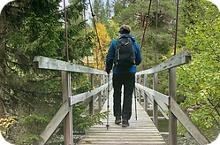 Man som promenerar på en spång i naturen