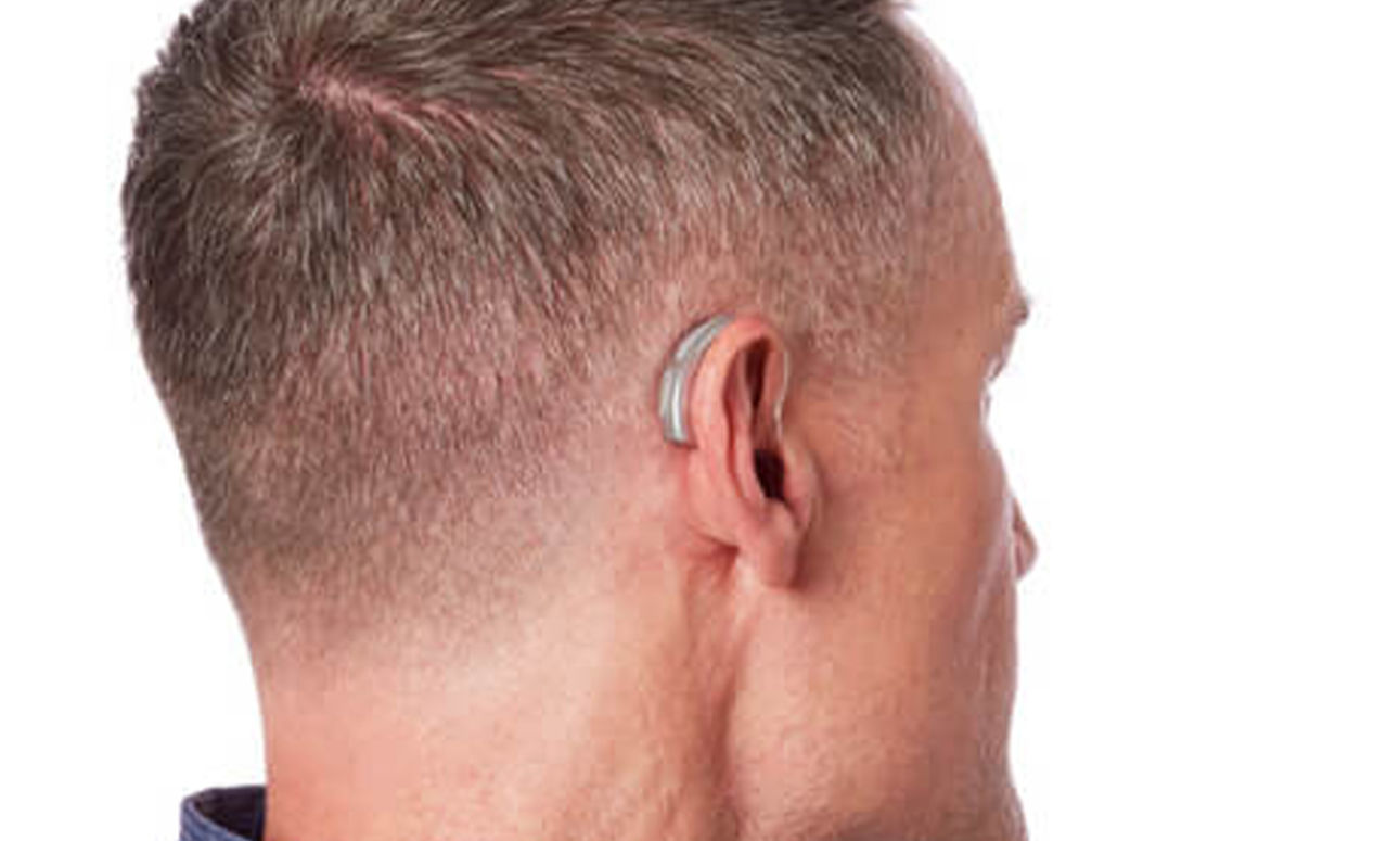 Side profile of a man wearing a Behind-The-Ear hearing aid.