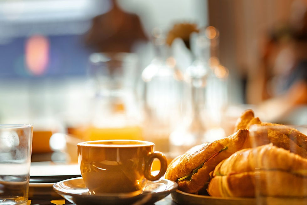 A breakfast plate of croissants beside a cup of coffee on a table