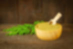 Moringa powder and leaves in a rustic wooden bowl
