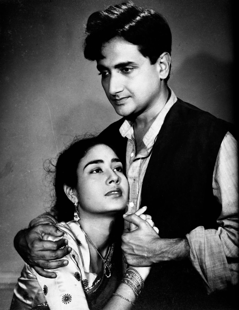 a black and white photo of a man and woman holding hands