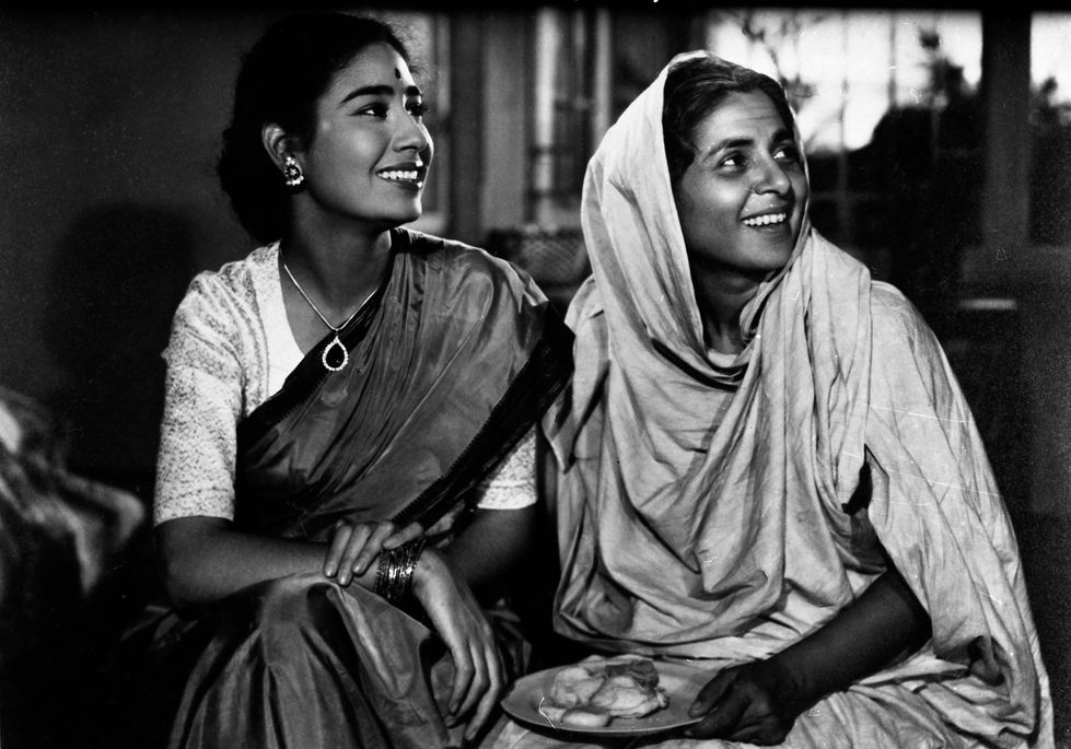 a black and white photo of two women sitting next to each other