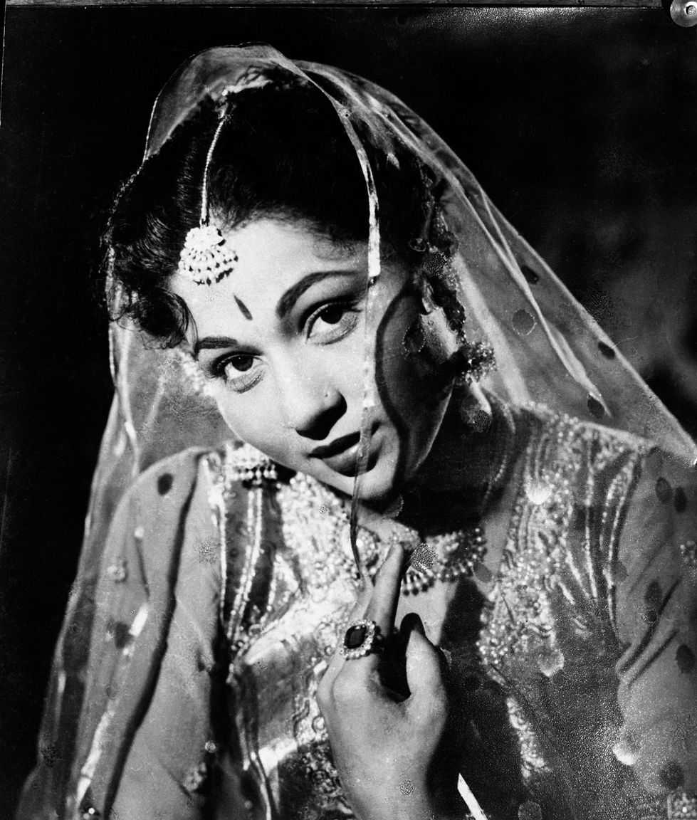 a black and white photo of a woman wearing a veil