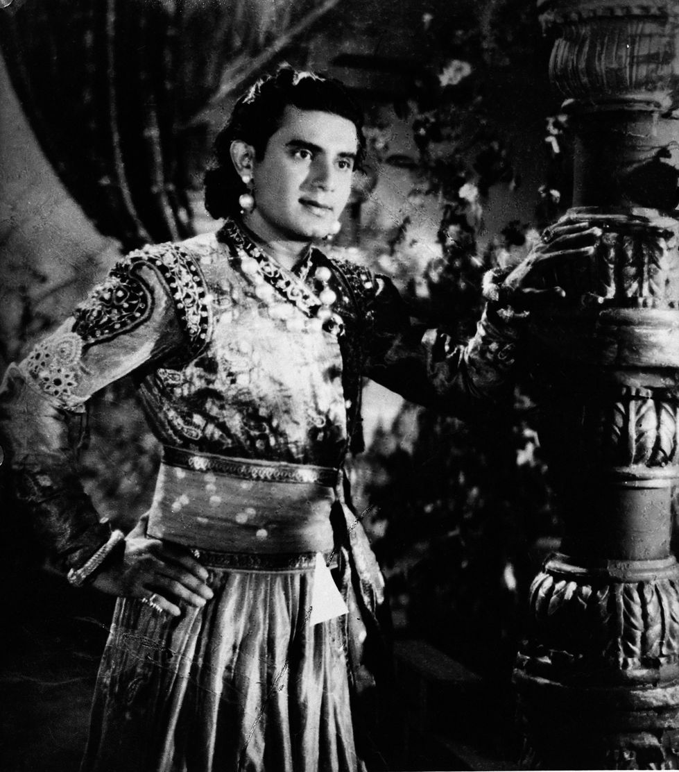 a black and white photo of a man with his hands on his hips