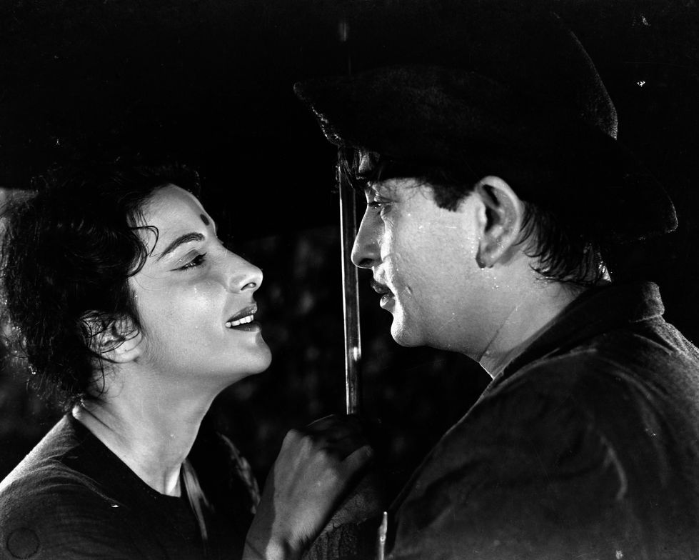 a black and white photo of a man and woman looking at each other