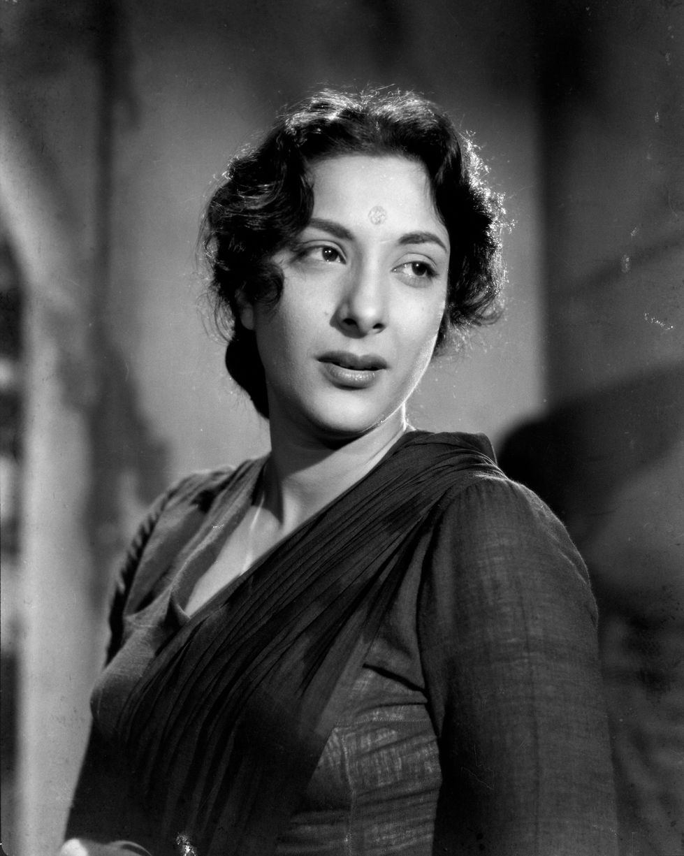a woman with a bindi on her forehead looks at the camera