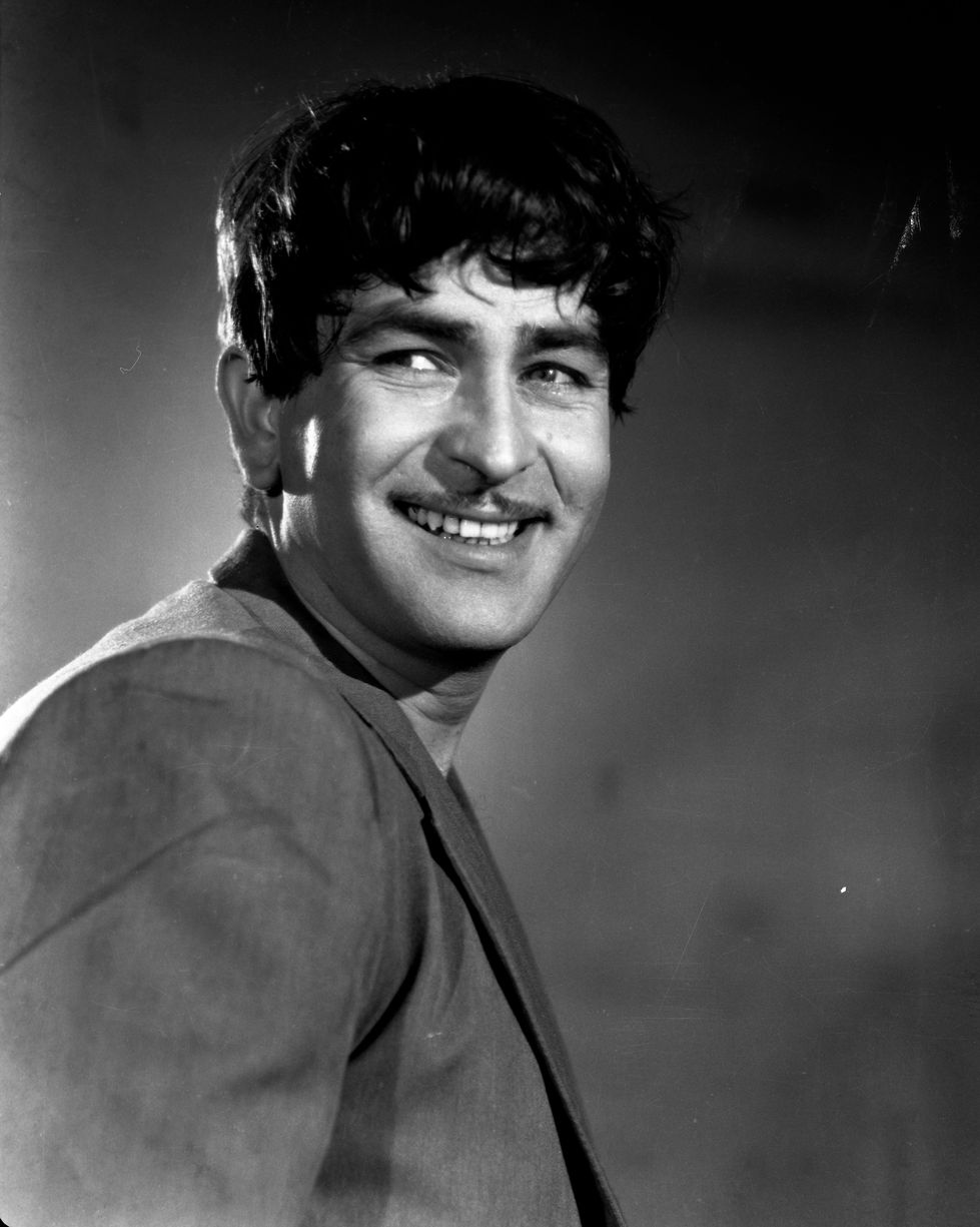 a man with a mustache is smiling in a black and white photo