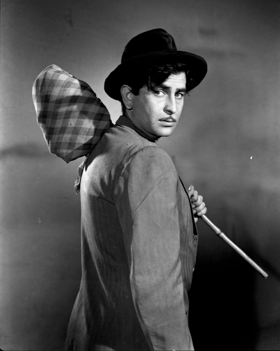 a man in a hat is holding a bag and a cane