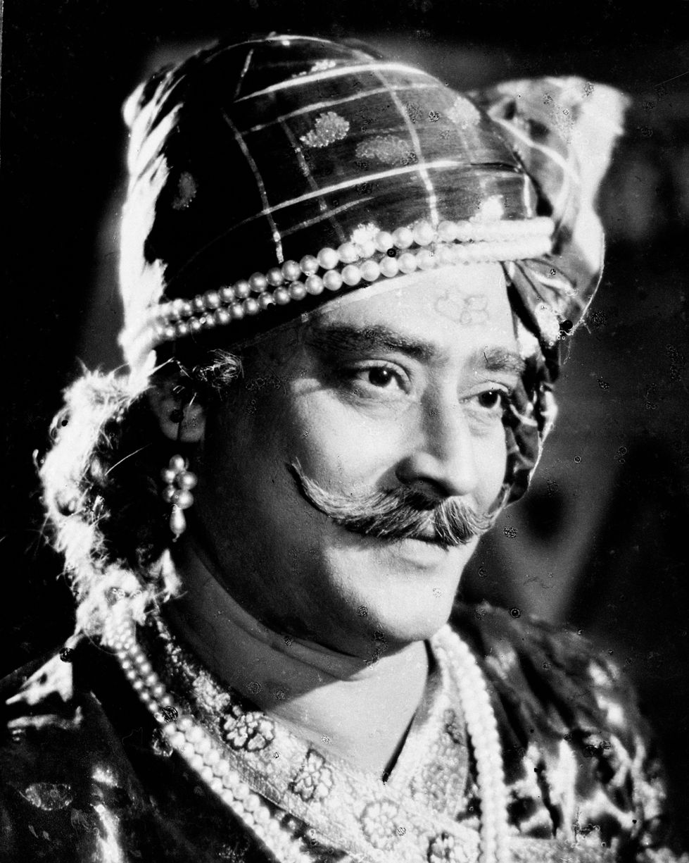 a man with a mustache wearing a turban and pearls