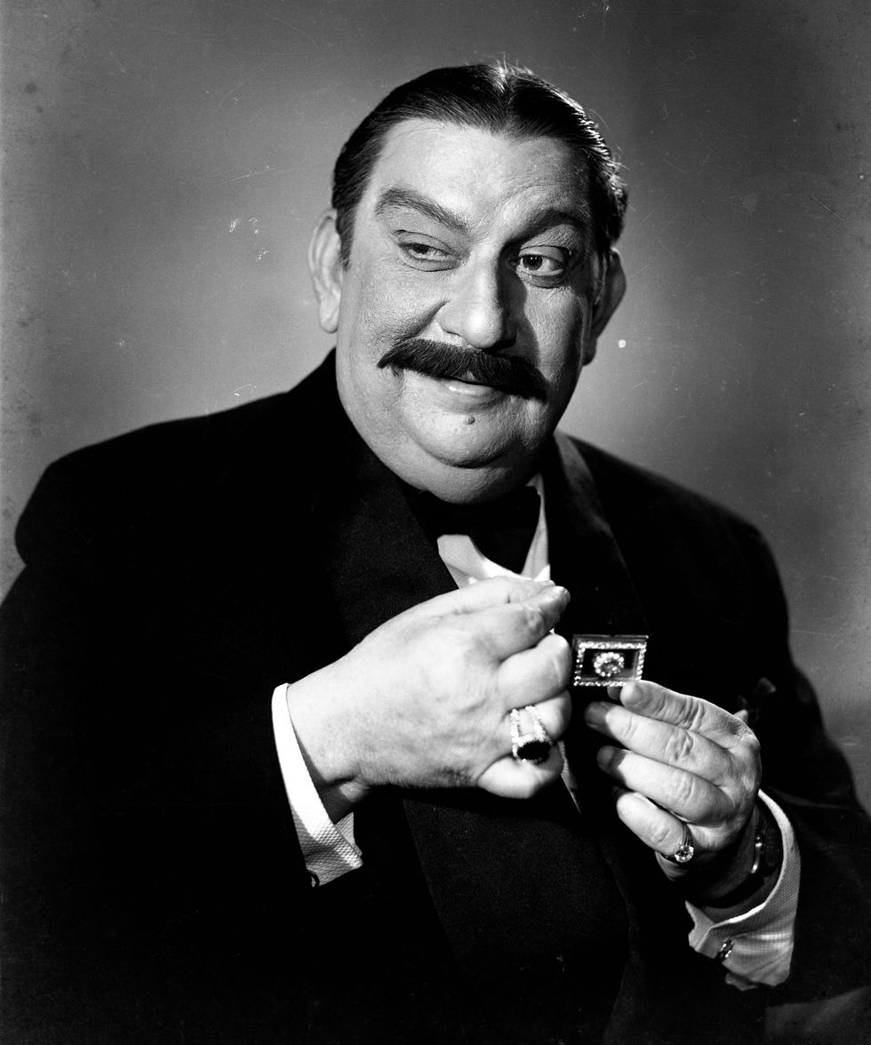 a man with a mustache is holding a postage stamp