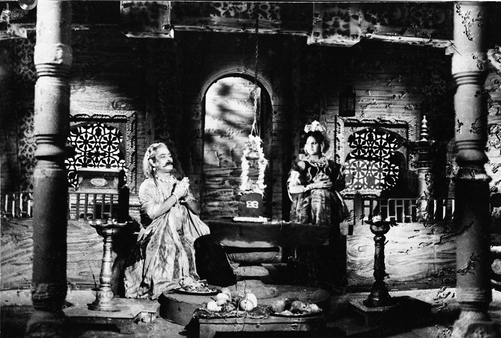 a black and white photo of a man and woman in a room with the letter b on the wall