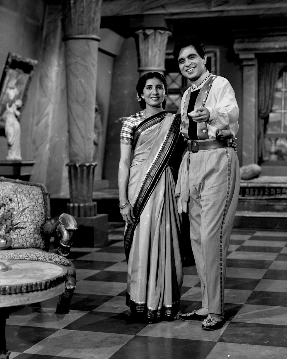 a black and white photo of a man and woman standing next to each other