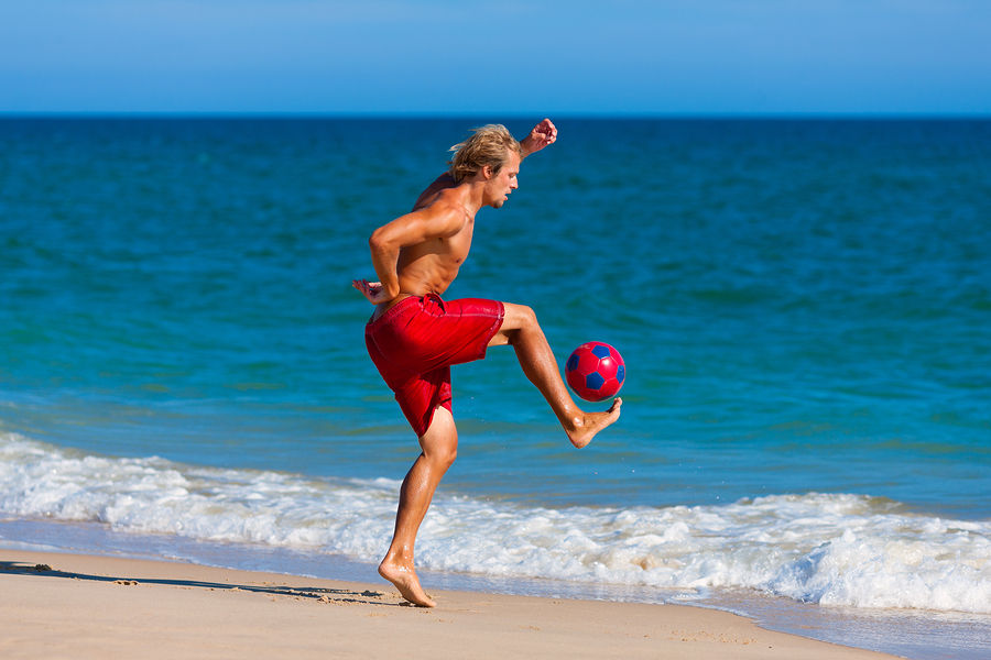 bigstock-Young-man-on-the-beach-playing-20346341
