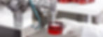 Hard mechanism of packing ready beauty cream into red container. A factory worker dressed