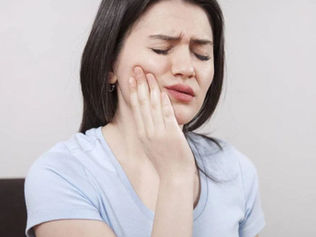 A man clutching her jaw with TMJ pain