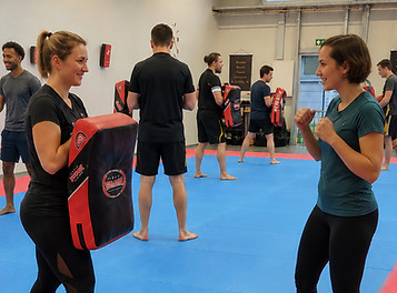 Frauen üben SD Self Defense mit Schlagpolstern in Rülzheim.