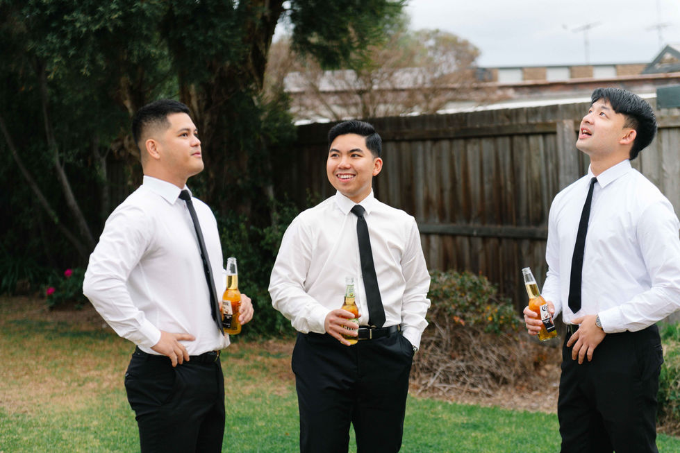 a man in a white shirt is holding a bottle of corona beer
