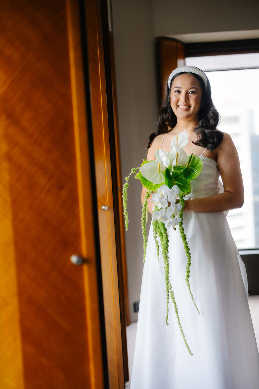 a woman in a white dress is holding a bouquet of flowers