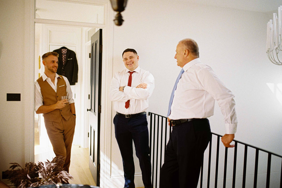 a man in a white shirt with a red tie is talking to two other men