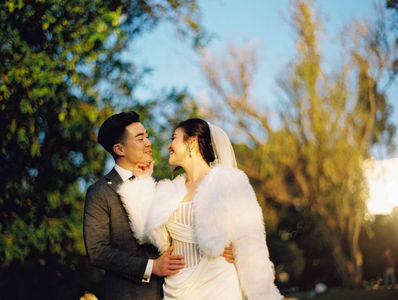 Bride and groom embrace in the gardens drenched in sunset light