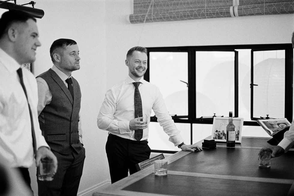 a man in a suit stands next to a man in a tie