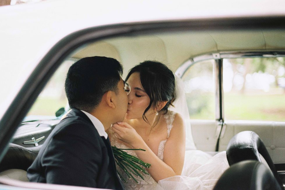 a bride and groom kissing in the back of a car