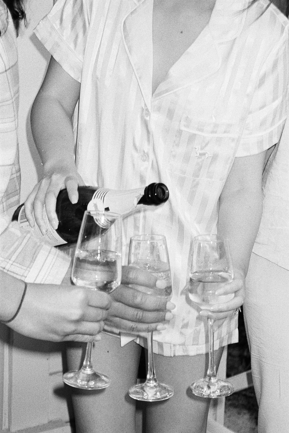 a person pouring a bottle of champagne into a glass