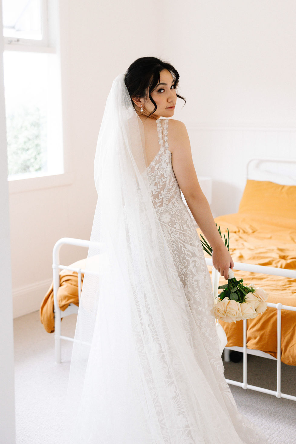 a woman in a wedding dress is holding a bouquet of flowers