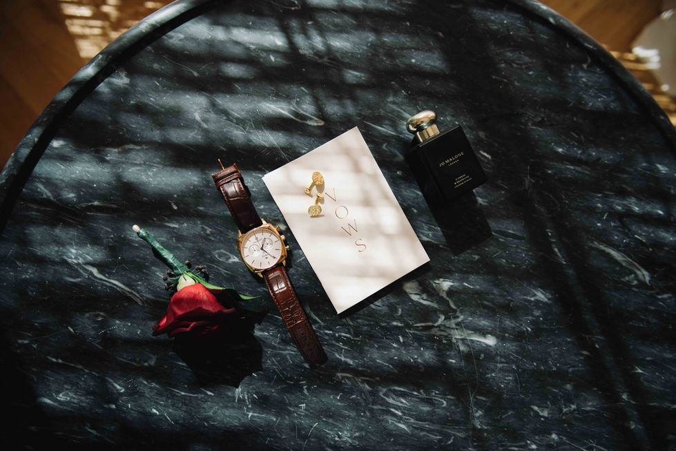 a bottle of jo malone perfume next to a watch