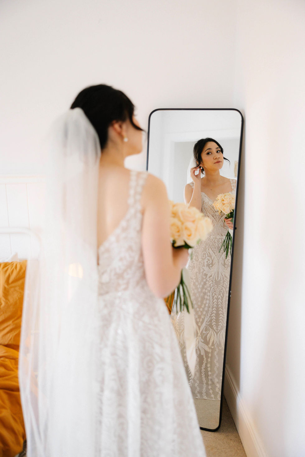 a woman in a wedding dress is looking at herself in a mirror