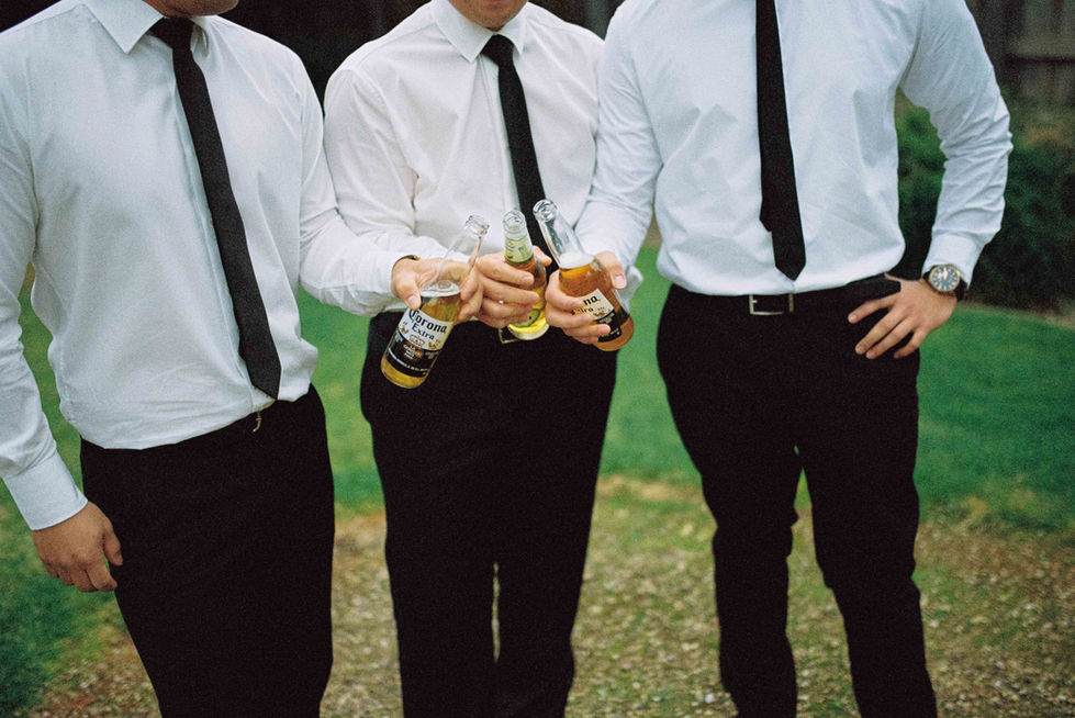 three men are holding bottles of corona beer