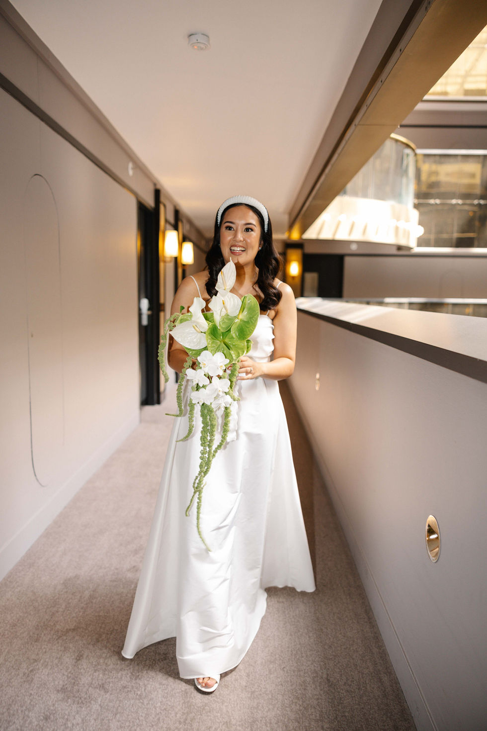 a woman in a white dress is holding a bouquet of flowers