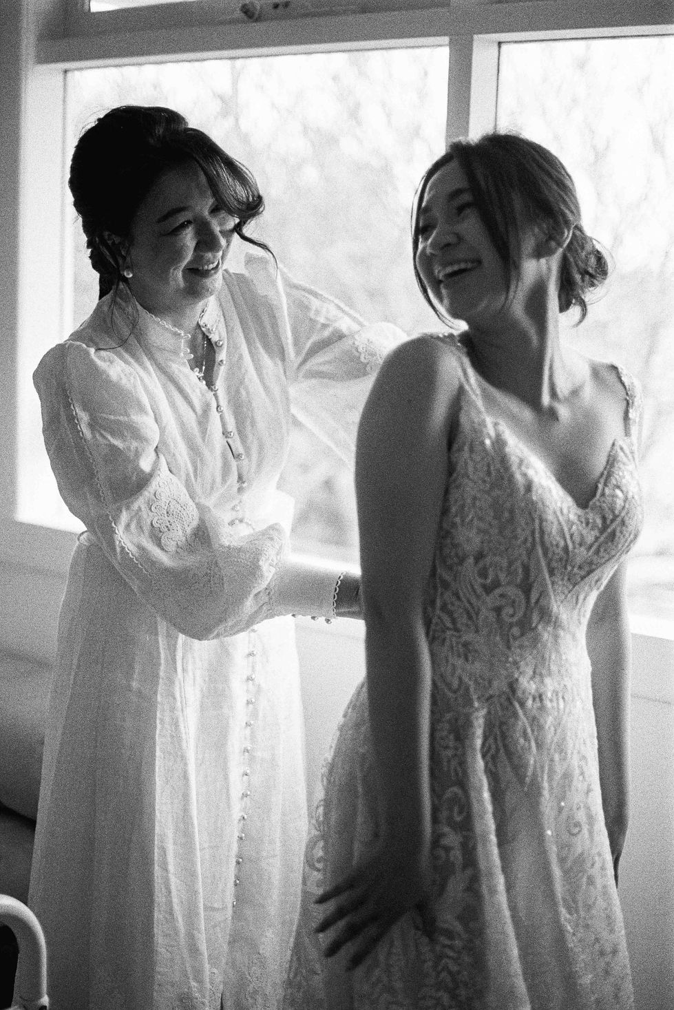 a woman in a white dress is helping another woman in a white dress