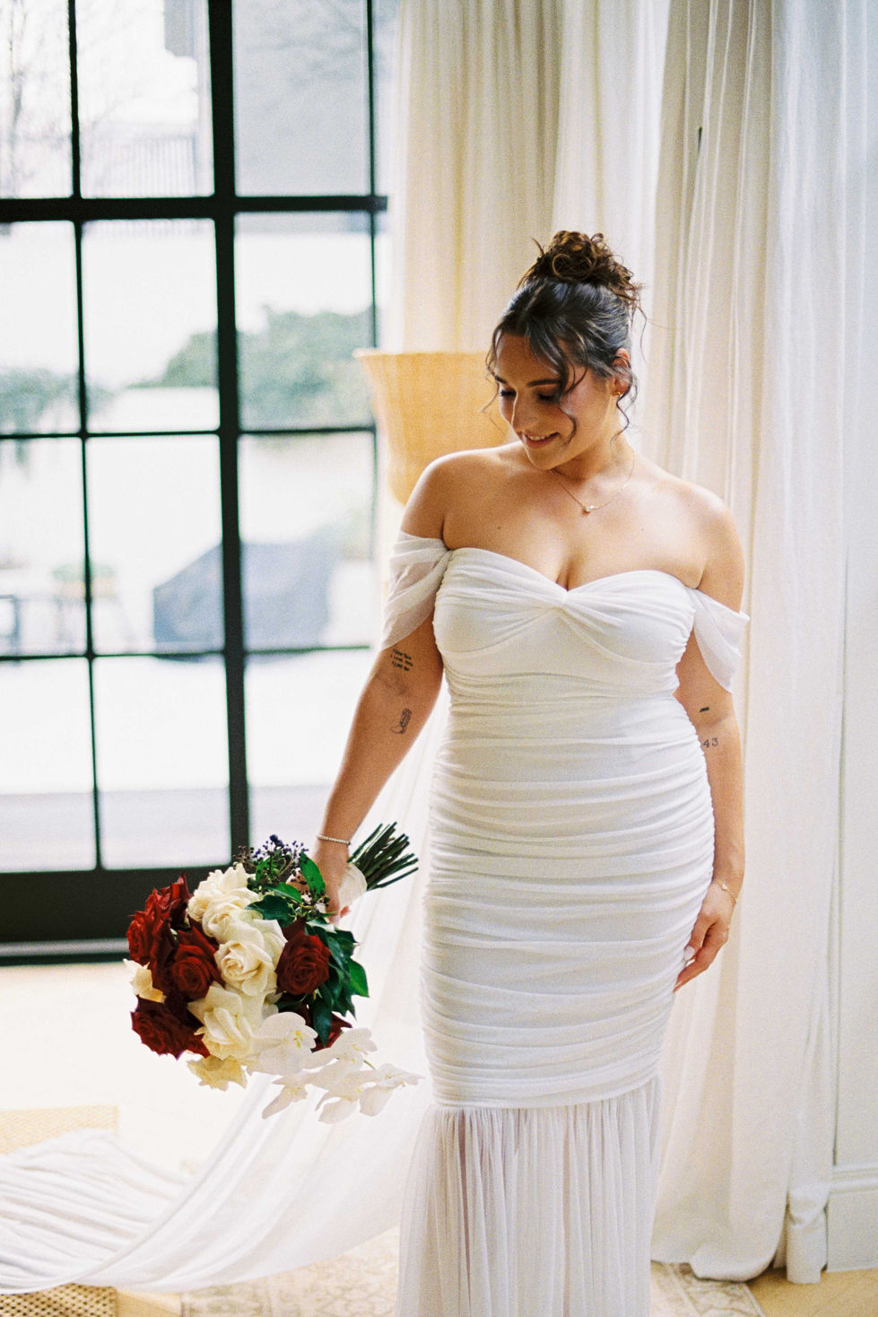 a woman in a white dress holds a bouquet of flowers