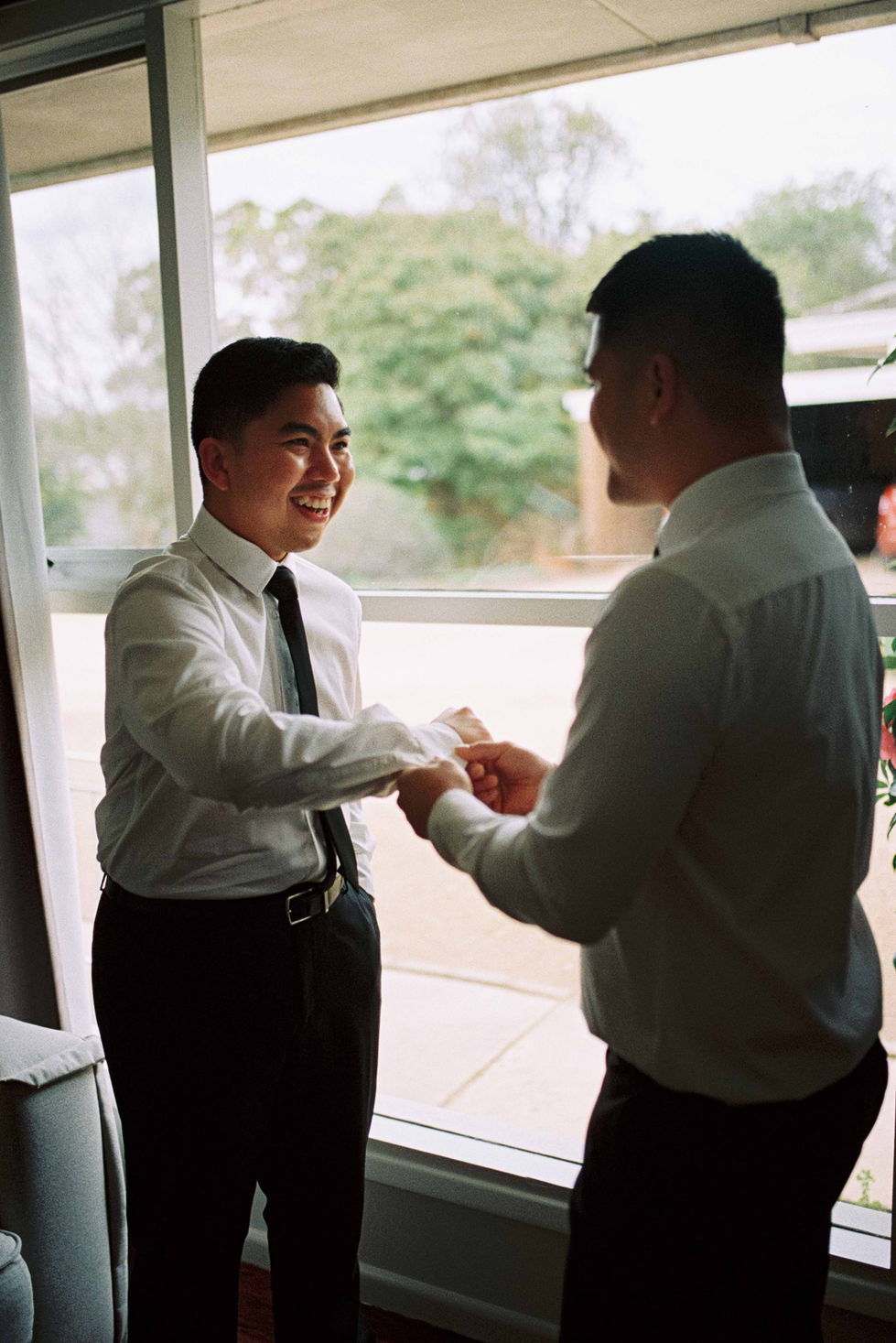 a man in a white shirt and tie shakes hands with another man