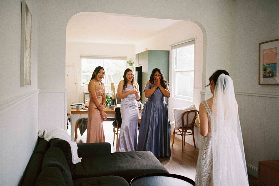 a bride and her bridesmaids are standing in a living room