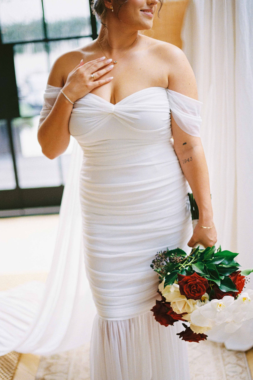 a woman in a white dress has a tattoo on her arm that says 1943